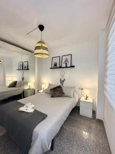 een slaapkamer met een groot wit bed en een lamp bij Apartamento La Carihuela 2 in Torremolinos