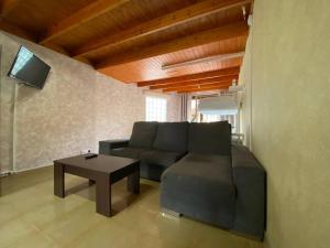 een woonkamer met een bank en een tafel bij El Olivar Paraíso Playa in Parque Holandes