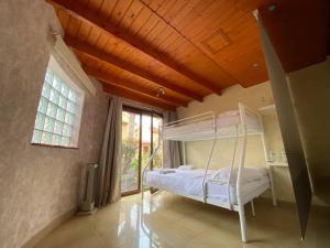 1 dormitorio con 1 cama blanca en una habitación con ventana en El Olivar Paraíso Playa, en Parque Holandes