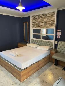 a bedroom with a large bed with a blue ceiling at โรงแรมกู๊ดอินน์ in Phra Nakhon Si Ayutthaya