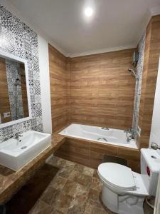 a bathroom with a tub and a toilet and a sink at โรงแรมกู๊ดอินน์ in Phra Nakhon Si Ayutthaya