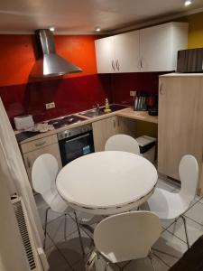 a kitchen with a white table and white chairs at Ferienwohnung Kleine Rütsche in Limburg an der Lahn