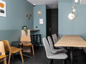 une salle à manger avec des tables et des chaises en bois dans l'établissement Hôtel Baudouin, à Valenciennes