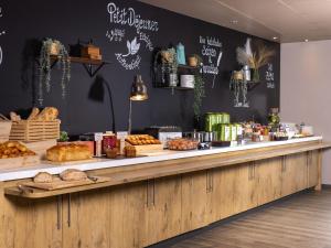 a bakery counter with bread and pastries on it at Hôtel Baudouin in Valenciennes