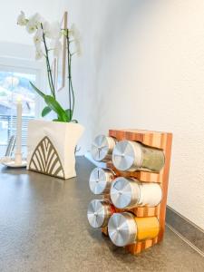 um suporte de especiarias de madeira com copos sobre uma mesa em Sunset Club - Nesselwang Chalets Nr 1 em Nesselwang