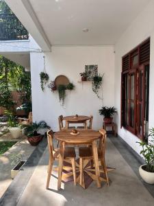 a wooden table and chairs on a patio at The Native Weligama in Weligama