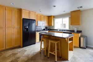 a kitchen with wooden cabinets and a black refrigerator at San Jose 3br w pool spa patio parking SFO-1537 in San Jose