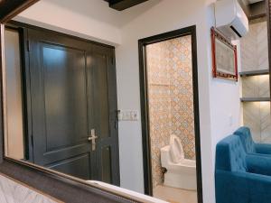 a bathroom with a mirror and a toilet and a door at Luxurious Chinatown Hideaway in Ho Chi Minh City