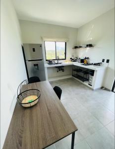 uma cozinha com uma mesa de madeira e uma cozinha com um balcão em La Ventana Apartments Torote #5 em La Ventana