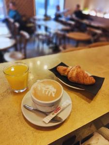 a cup of coffee and a croissant on a table at Les Appartements de Babel République in Marseille