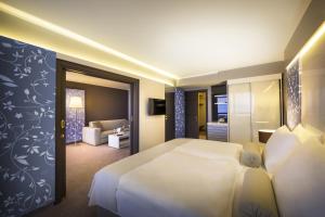 ein Hotelzimmer mit einem Bett und einem Wohnzimmer in der Unterkunft Hotel Excelsior - Liburnia in Lovran
