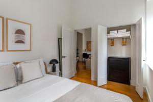 a white bedroom with a bed and a living room at FiDi 1br w 3-story gym doorman game room NYC-1339 in New York