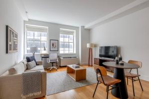 a living room with a couch and a table at FiDi 1br w 3-story gym doorman game room NYC-1341 in New York