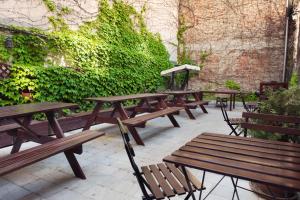 une rangée de bancs en bois assis sur une terrasse dans l'établissement Patio Hostel Dorms, à Bratislava