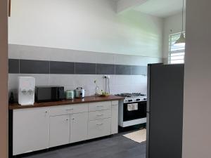 a kitchen with white cabinets and a black refrigerator at A home with private pool, Kebun Kecil in Tangga Batu