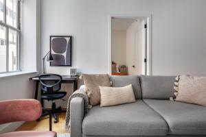 a living room with a gray couch and a desk at FiDi 1br w doorman gym nr wall street NYC-1342 in New York