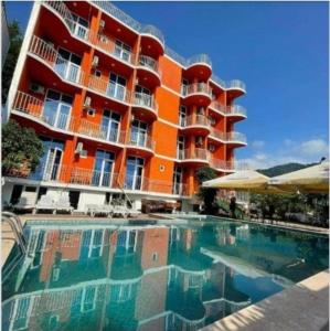 a hotel with a swimming pool in front of a building at Hotel Georgia in Gonio