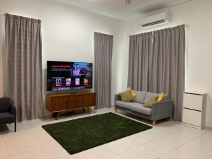 a living room with a couch and a flat screen tv at A home with private pool, Kebun Kecil in Tangga Batu