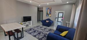 a living room with blue chairs and a table at Salama Apartments in Lusaka