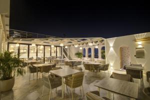 een restaurant met 's avonds tafels en stoelen bij Cygnett Collection K K Hotel in Faizābād