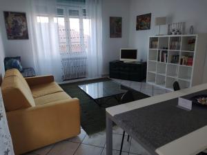 uma sala de estar com um sofá e uma mesa em Ca' Allegra - Centro em Asti