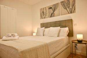 a bedroom with a large white bed with two towels at For You Rentals Encantadora Vivienda de 3 Dormitorios descubre el Confort que Estabas Buscando DSA434D in Madrid