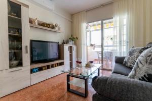 ein Wohnzimmer mit einem Sofa und einem TV in der Unterkunft rentafive Nuevo Junto a la Playa Ascensor in Santa Pola