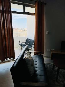 a living room with a couch and a large window at Coastal Bliss at Ongwe in Swakopmund