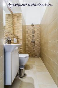 a bathroom with a white toilet and a sink at Summertime Apartments in Zadar