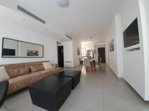 een woonkamer met een bank en een tafel bij Harav Kuk Royal Suites - Alefimmoed in Jeruzalem