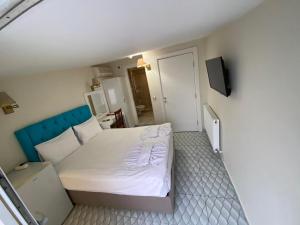 Dormitorio pequeño con cama blanca y cabecero azul en Timeks Suite Sultanahmet, en Estambul