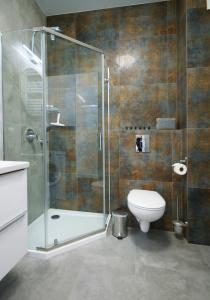 a bathroom with a glass shower and a toilet at IRS ROYAL APARTMENTS Apartamenty IRS Nadmorski Dwór 2 in Gdańsk
