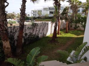 a view of a yard with palm trees and a building at Luxury Villa Jack Beach Resort Ocean Oasis View Panoramic in Casablanca