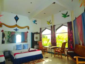 a bedroom with two beds and a table and chairs at MG Chateau Resort in El Nido