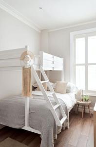 um quarto com uma cama branca e uma escada em Cute Beach House - 4 mins walk em Bournemouth