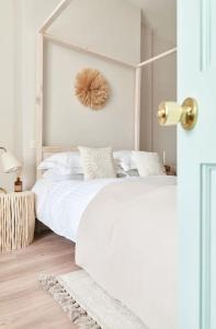 a white bedroom with a large white bed and a window at Cute Beach House - 4 mins walk in Bournemouth