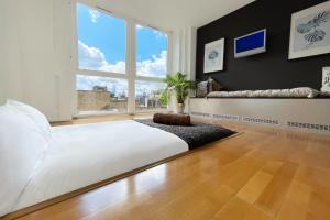 a bedroom with a large white bed and a large window at Quirky and Modern Clerkenwell Apartment in London