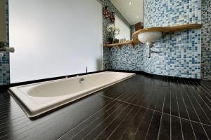a bath tub in a bathroom with blue tiles at Quirky and Modern Clerkenwell Apartment in London