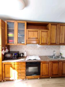 a kitchen with wooden cabinets and a stove top oven at Appartamento Pelmo in Borca di Cadore
