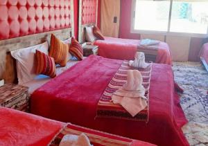 a hotel room with two beds with towels on them at Fantastic Desert Luxury Camp in Merzouga