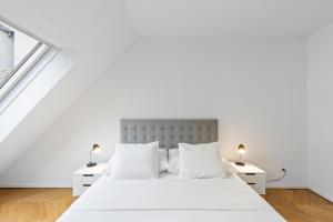 a white bedroom with a large bed and two night stands at Vienna Chic Residences #13 * Brand New * in Vienna