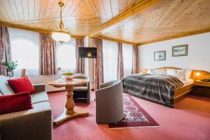 um quarto com uma cama e uma mesa em uma sala em Scheffer's Hotel em Altenmarkt im Pongau