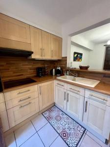 een keuken met witte kasten, een wastafel en een tapijt bij "L'oranger" Arles Terrasse in Arles
