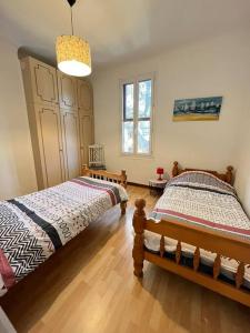 een slaapkamer met 2 aparte bedden en een kroonluchter bij "L'oranger" Arles Terrasse in Arles