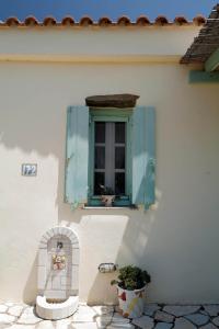a window with a blue shutter on a house at KALIMERA HOUSE in Karavás