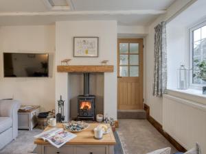 a living room with a fireplace and a table at 1 bed in Richmond 77600 in Easby