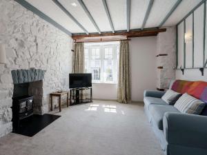 a living room with a blue couch and a stone wall at 4 Bed in New Quay 78589 in New Quay
