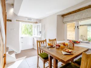 1 Bed in Bedford 79095 في Turvey: مطبخ وغرفة طعام مع طاولة وكراسي خشبية