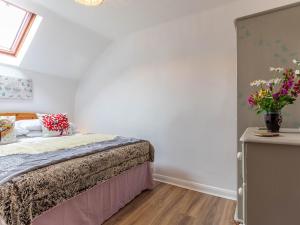 a bedroom with a bed and a vase of flowers at 2 Bed in South Molton 78302 in Kings Nympton