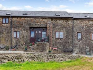 a brick building with a stone wall and a door at 2 Bed in South Molton 78302 in Kings Nympton